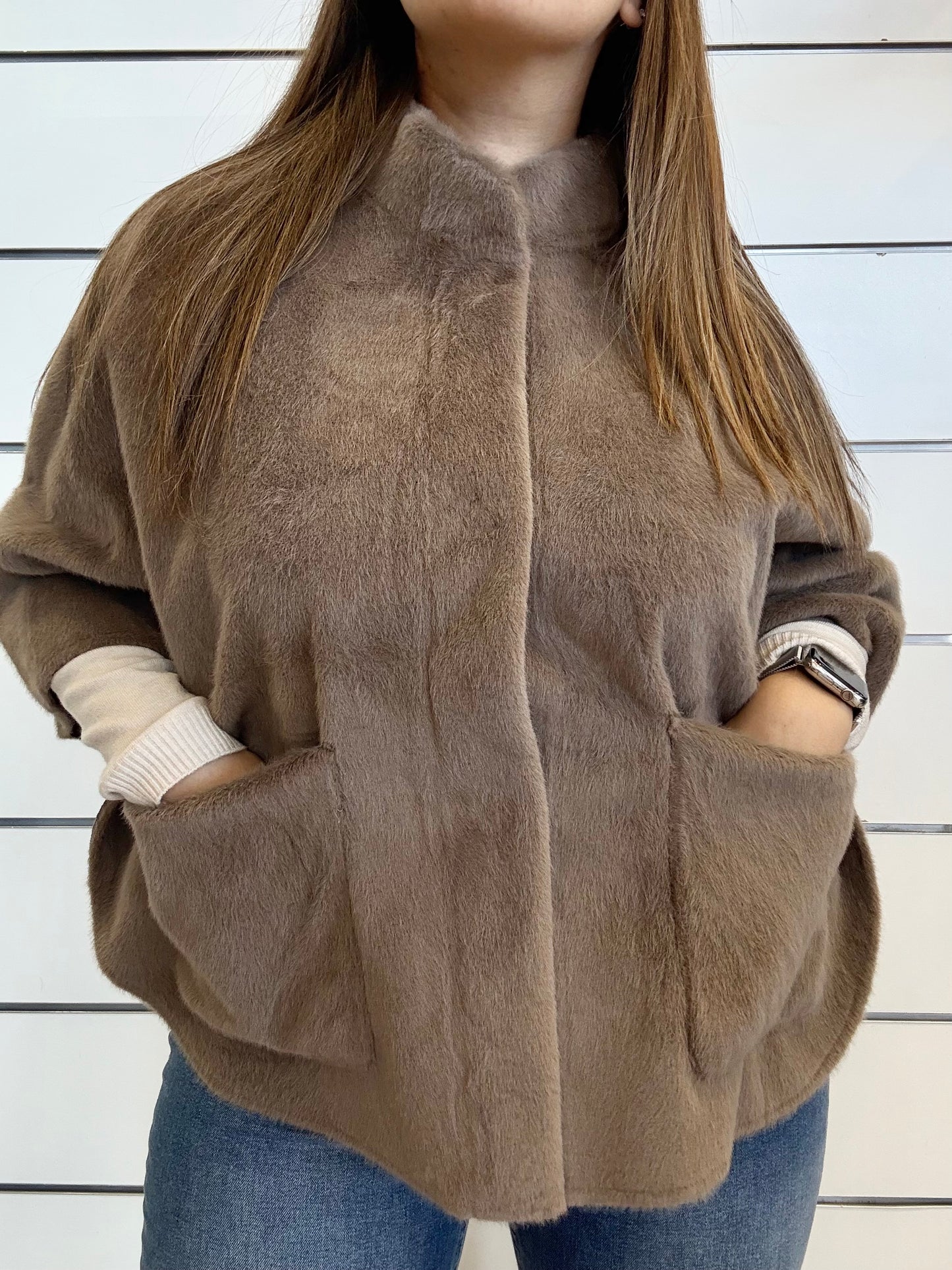 Mantella in ecopelliccia beige con tasche frontali e design moderno per un look elegante
