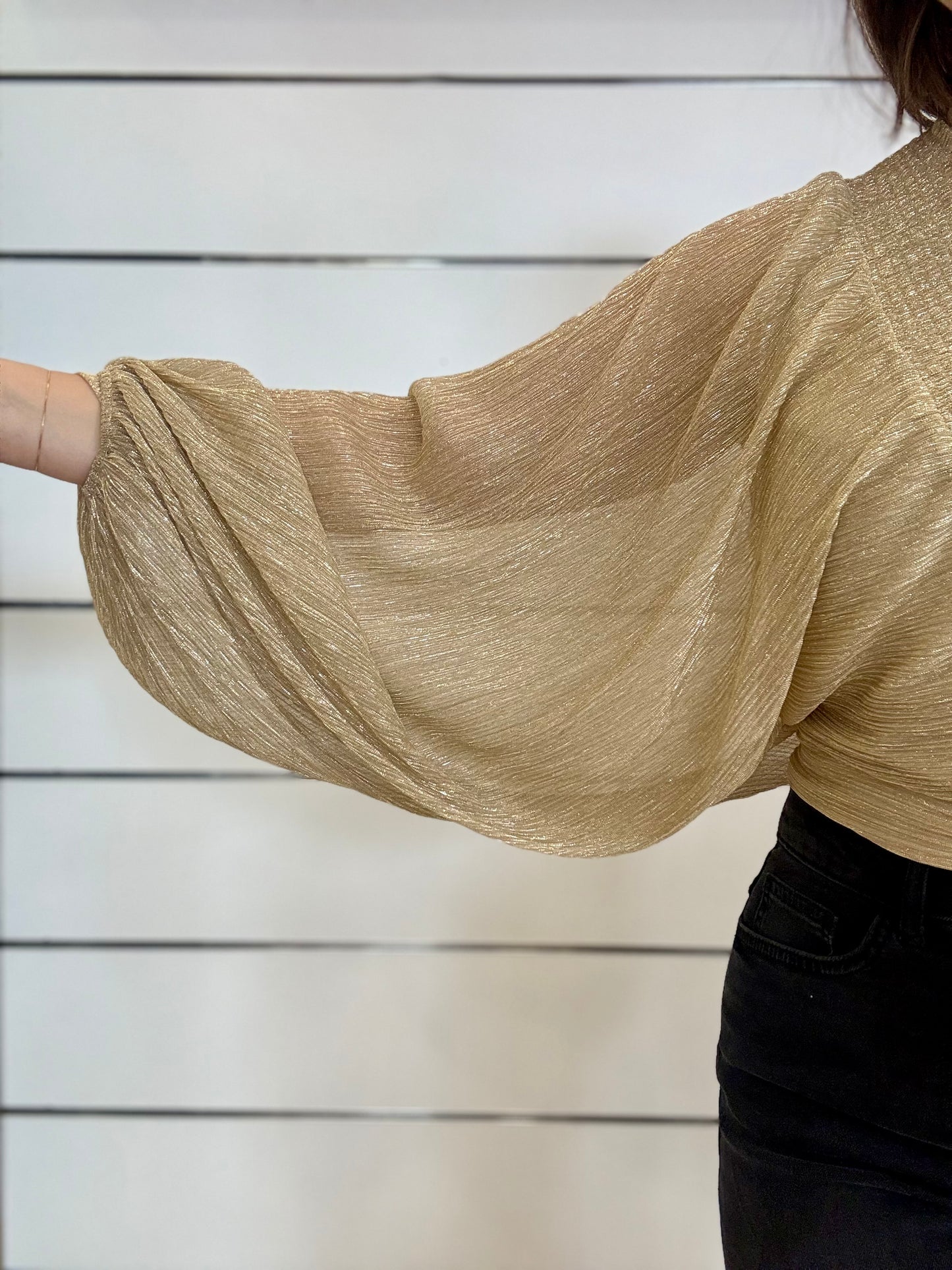 Blusa oro con maniche ampie velate in tessuto leggero con design elegante