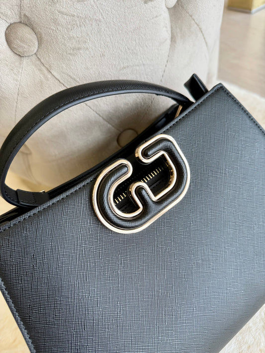 Borsa top handle nera in similpelle con chiusura decorativa per un look elegante e moderno