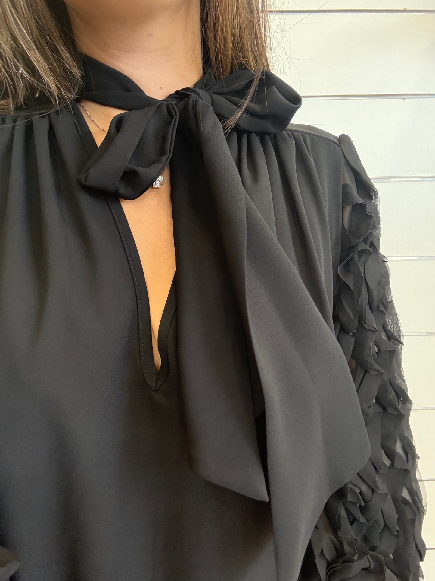 Camicia nera con dettagli raffinati con maniche lavorate e colletto a fiocco