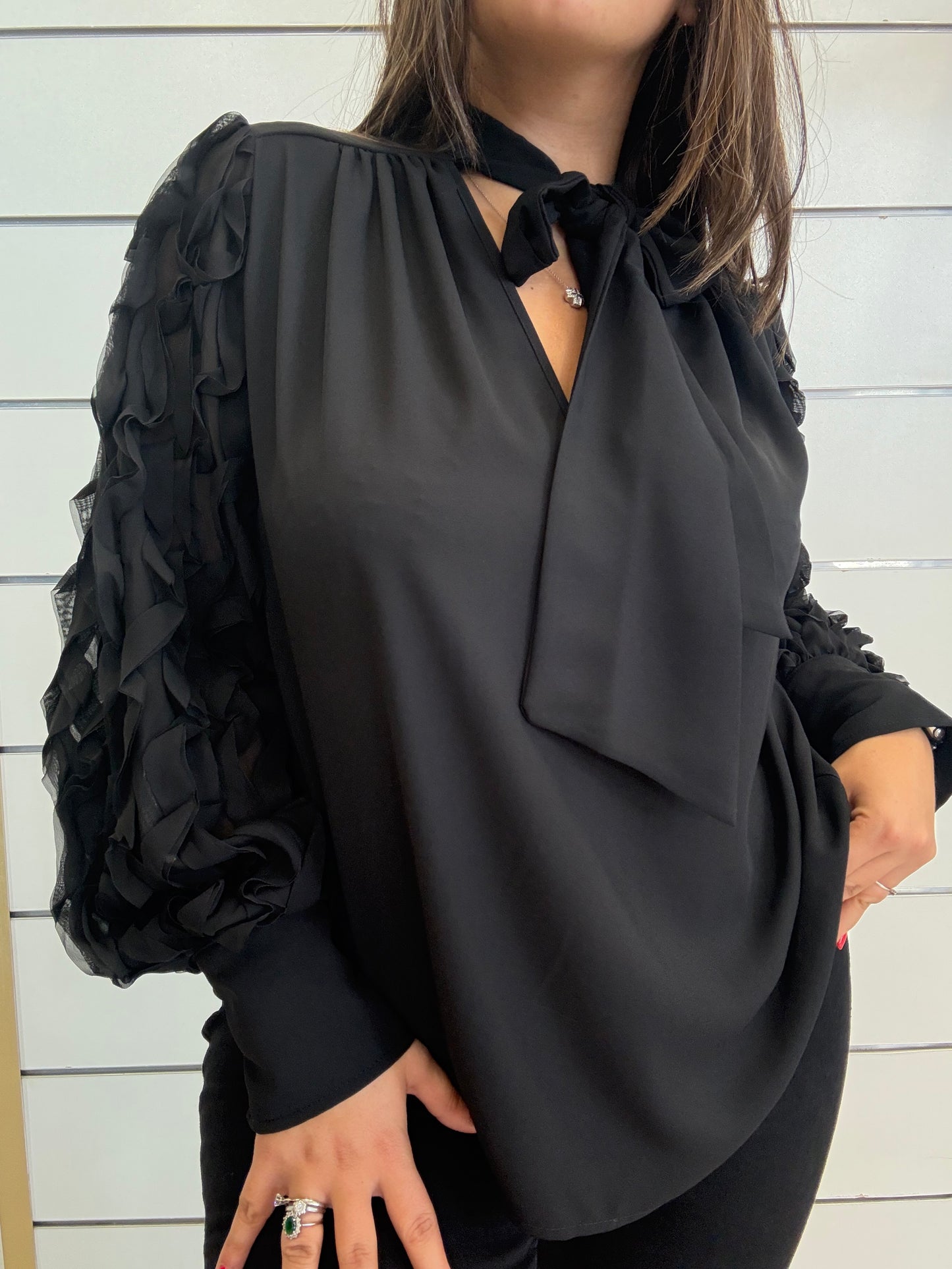 Camicia nera con dettagli raffinati con maniche lavorate e nodo elegante per un look sofisticato