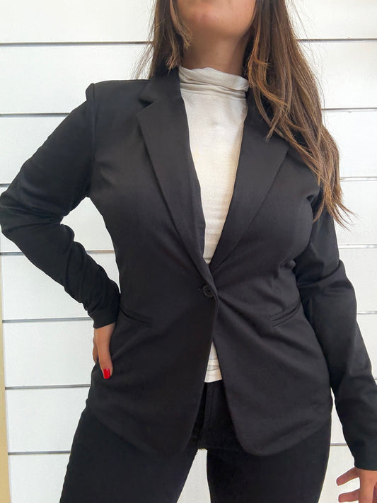 Giacca monopetto in punto Milano nera indossata con una maglia bianca per un look elegante