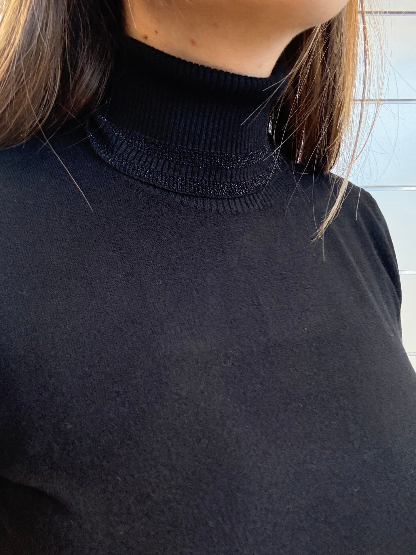 Golfino nero a collo alto con manica corta, realizzato in tessuto morbido e aderente per un look elegante.