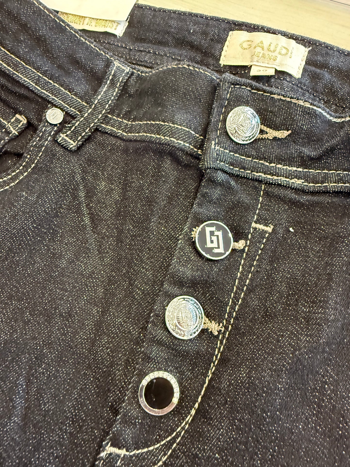 Dettaglio dei jeans da donna con bottoni Gaudì, neri e in denim resistente