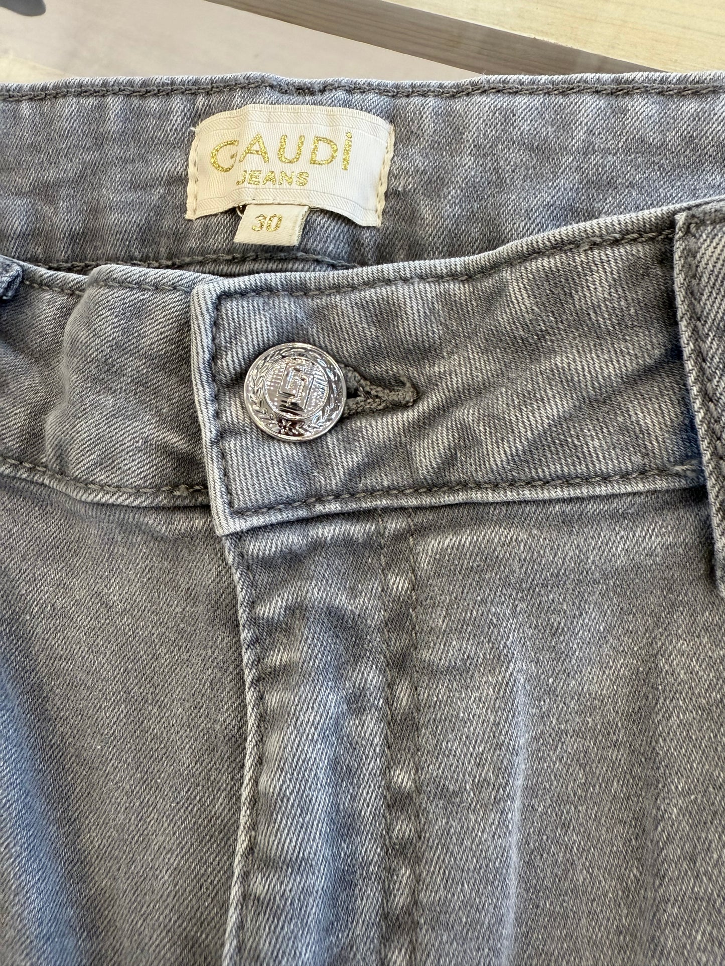 Dettaglio dei jeans da donna cropped in cotone used grigio di Gaudì con strass e bottone lucido