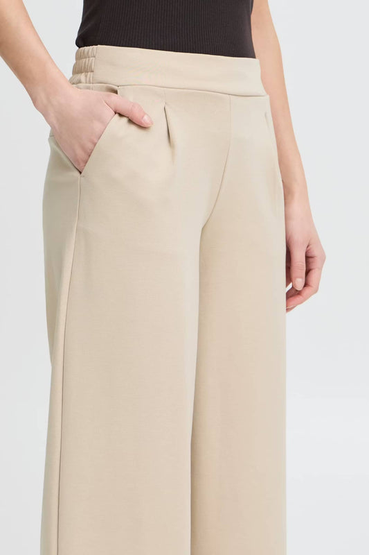 Pantalone largo beige in tessuto morbido con tasche laterali per un look elegante e comodo