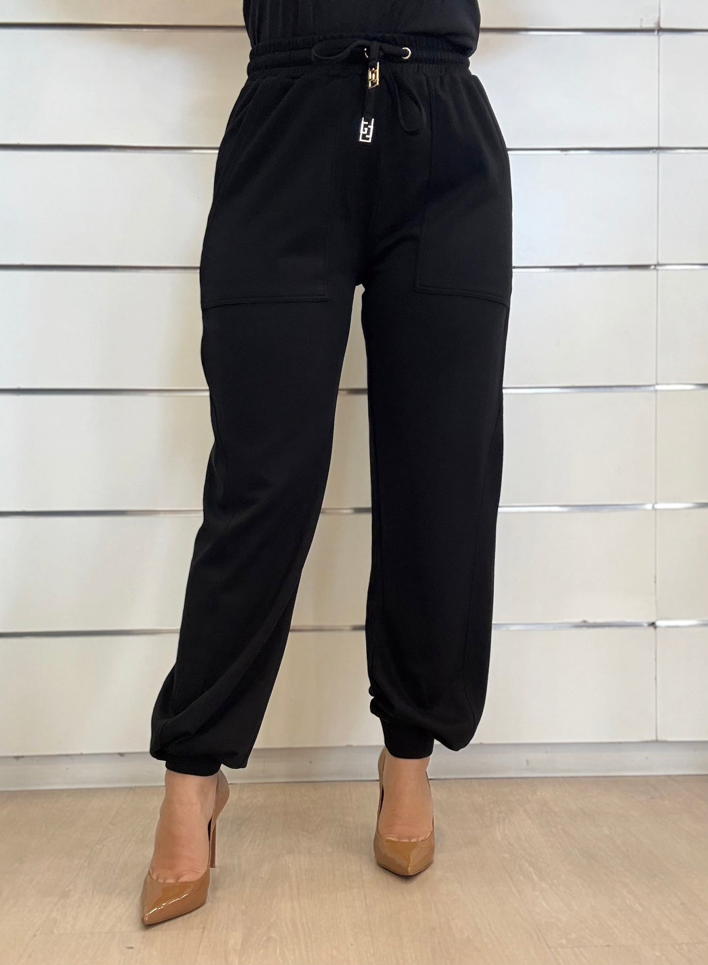 Pantaloni jogging nero da donna con coulisse logata, in stile casual, abbinati a tacchi alti