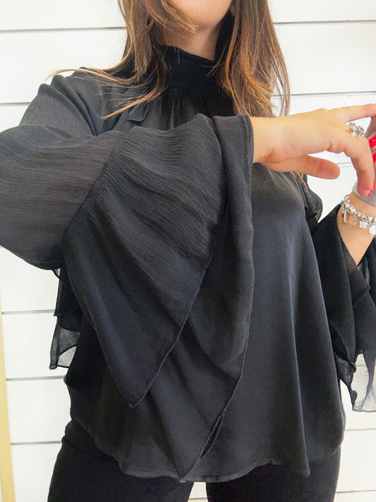Camicia nera con maniche trasparenti e volant per un look elegante e sofisticato