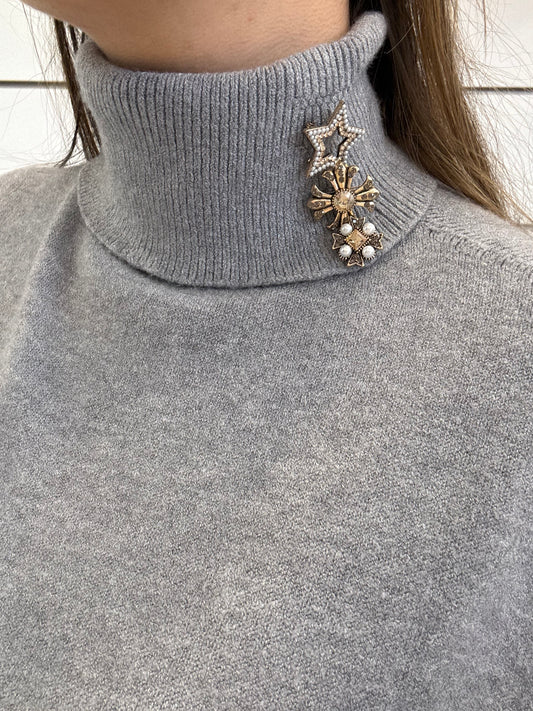 Gilet grigio con spille e colletto alto per un look elegante e moderno