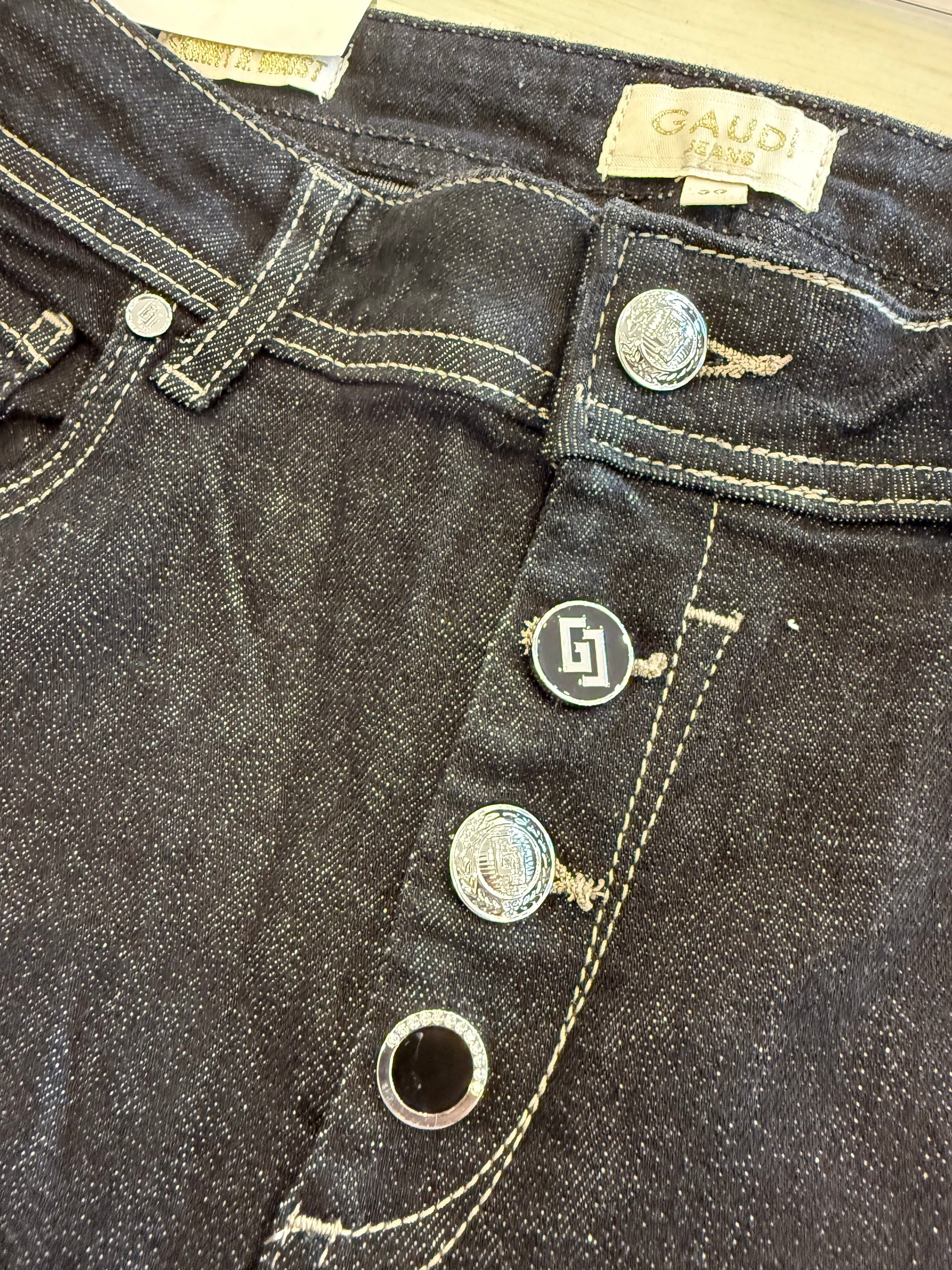 Dettaglio dei jeans da donna con bottoni Gaudì, neri e in denim resistente