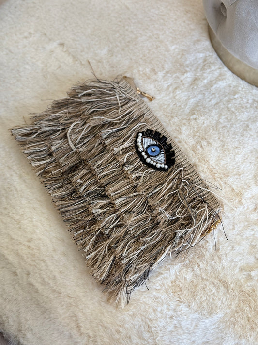 Pochette a mano Sorena clutch beige elegante con dettagli frangi e decorazione oculare