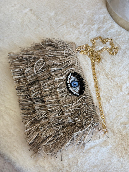 Pochette a mano Sorena clutch beige elegante con frange e decorazione a occhio
